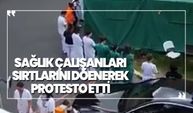 Sağlık çalışanları sırtlarını dönerek protesto etti